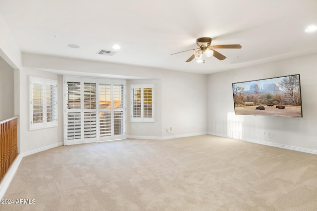 carpeted spare room featuring ceiling fan