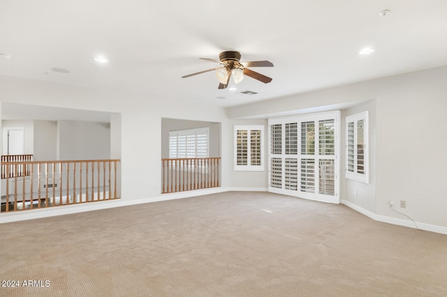 spare room featuring light carpet and ceiling fan