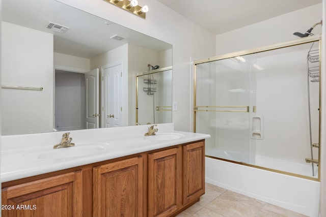 bathroom featuring tile patterned floors, vanity, and bath / shower combo with glass door