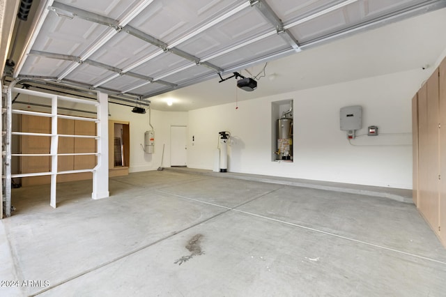 garage with strapped water heater, a garage door opener, and gas water heater