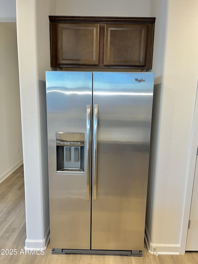 kitchen featuring dark brown cabinets, baseboards, stainless steel fridge, and light wood-style flooring