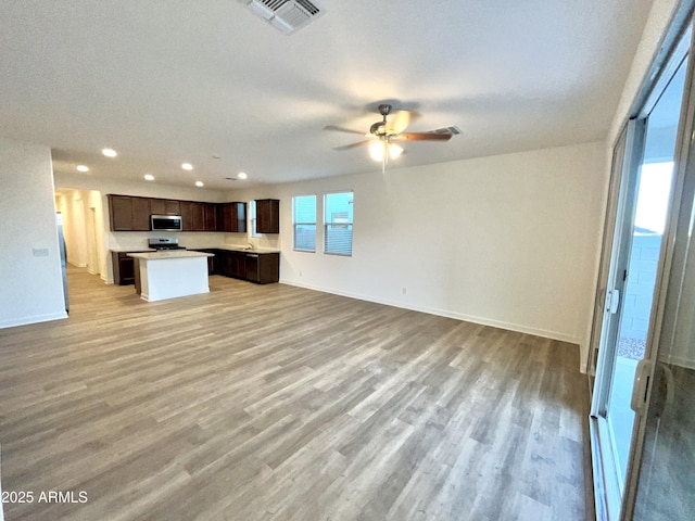 unfurnished living room featuring ceiling fan, light wood finished floors, recessed lighting, baseboards, and visible vents