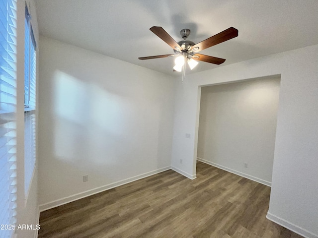spare room with a ceiling fan, baseboards, and wood finished floors