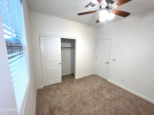 unfurnished bedroom with carpet floors, visible vents, a closet, baseboards, and a ceiling fan