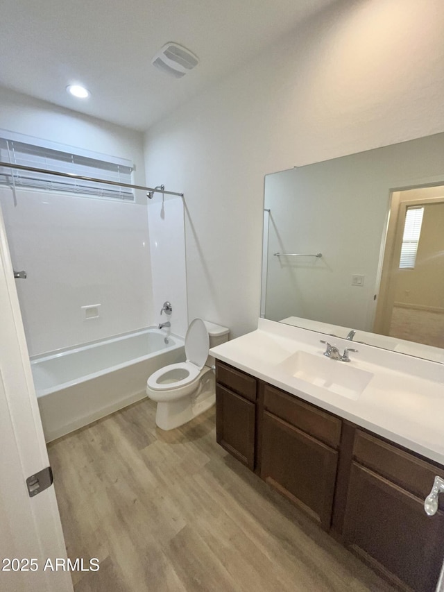 full bathroom with vanity, wood finished floors, toilet, recessed lighting, and shower / washtub combination