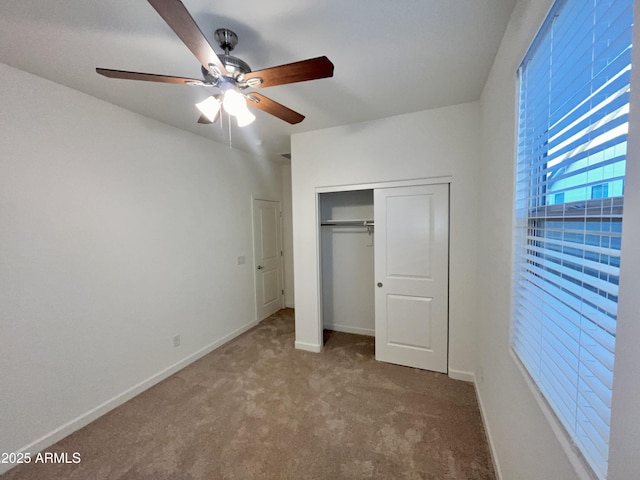 unfurnished bedroom with a ceiling fan, baseboards, carpet, and a closet