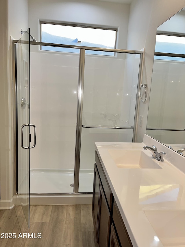 bathroom featuring a stall shower, a wealth of natural light, and wood finished floors