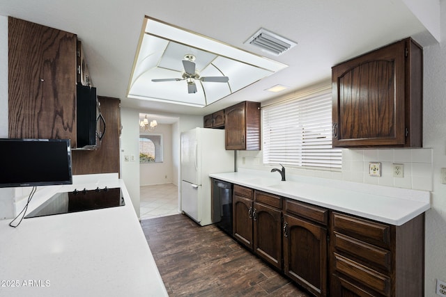 kitchen with ceiling fan with notable chandelier, sink, dark wood-type flooring, black appliances, and dark brown cabinets