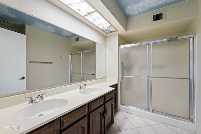 bathroom with tile patterned flooring, vanity, and an enclosed shower