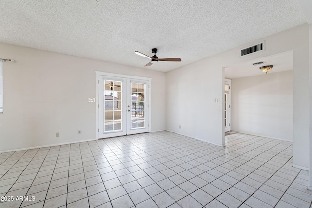 tiled spare room with ceiling fan, a textured ceiling, and french doors