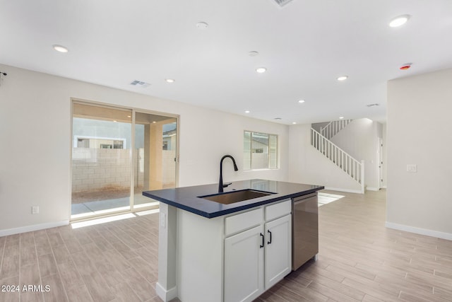 kitchen with white cabinets, plenty of natural light, dishwasher, and sink