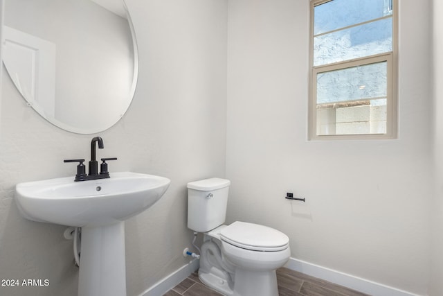 bathroom featuring plenty of natural light, toilet, and wood-type flooring