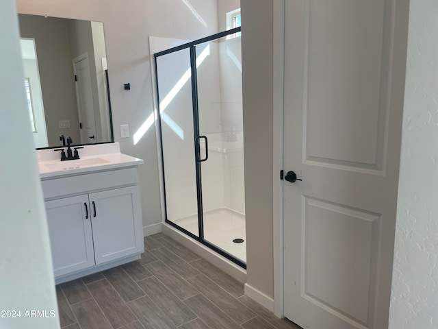 bathroom featuring vanity and a shower with door