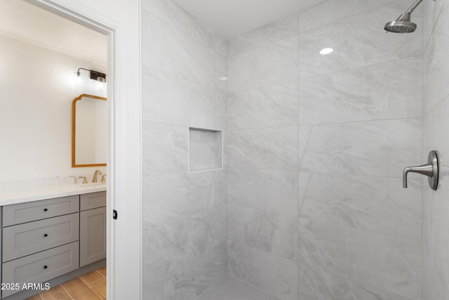 bathroom with vanity, hardwood / wood-style floors, and a tile shower