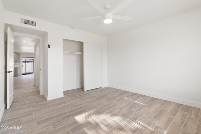 unfurnished bedroom with ceiling fan and a closet