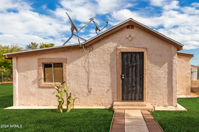 view of exterior entry featuring a yard