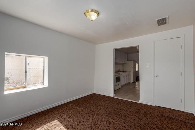 unfurnished room with hardwood / wood-style floors and sink