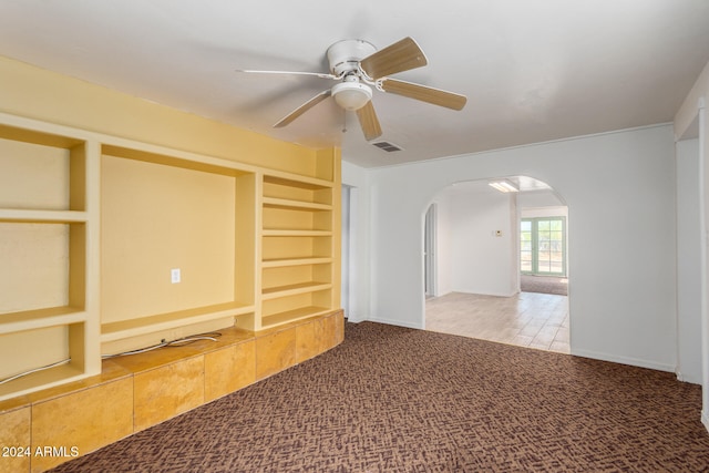 unfurnished living room featuring carpet and ceiling fan