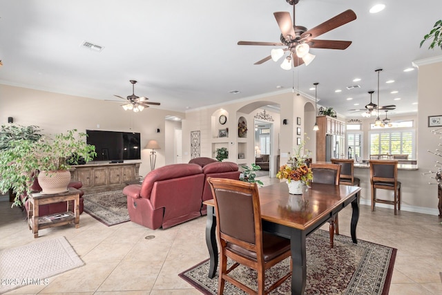 dining space featuring light tile patterned floors, arched walkways, a ceiling fan, ornamental molding, and recessed lighting