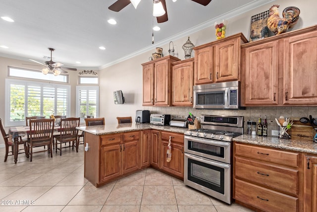 kitchen with light tile patterned floors, decorative backsplash, appliances with stainless steel finishes, ornamental molding, and a peninsula