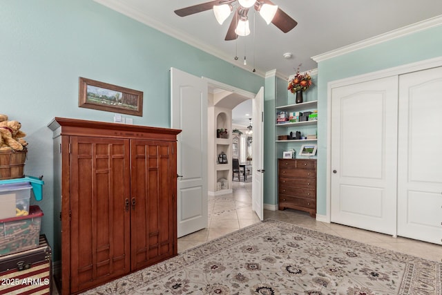 bedroom featuring arched walkways, light tile patterned floors, a closet, ornamental molding, and a ceiling fan