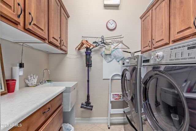 laundry room with cabinet space, light tile patterned floors, baseboards, and independent washer and dryer