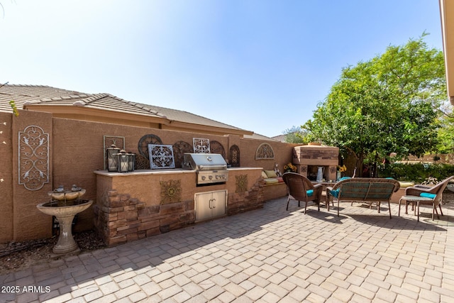 view of patio featuring an outdoor living space with a fireplace and area for grilling