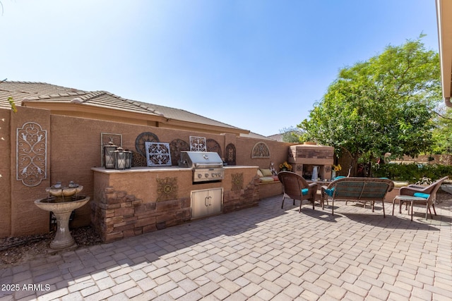 view of patio / terrace with exterior kitchen, grilling area, and an outdoor living space with a fireplace