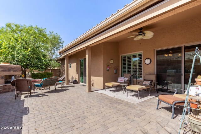 view of patio / terrace featuring an outdoor fireplace and a ceiling fan