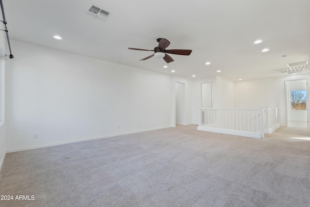 spare room featuring ceiling fan and light colored carpet