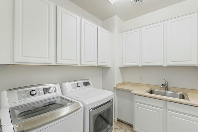 washroom featuring cabinets, independent washer and dryer, and sink