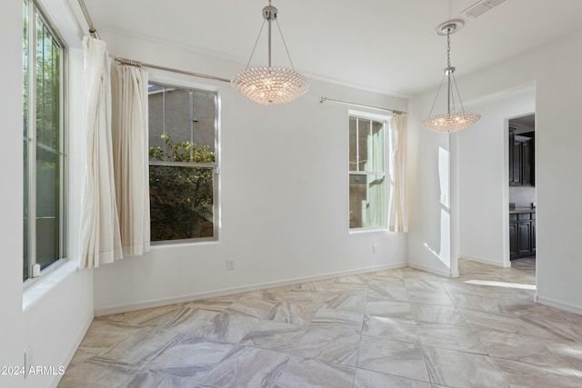 unfurnished dining area with an inviting chandelier