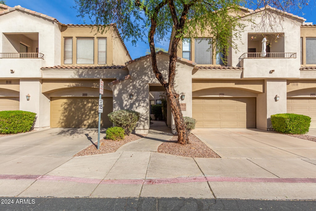 view of front of home with a garage and a balcony