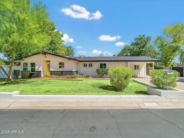 ranch-style house with a front lawn and brick siding