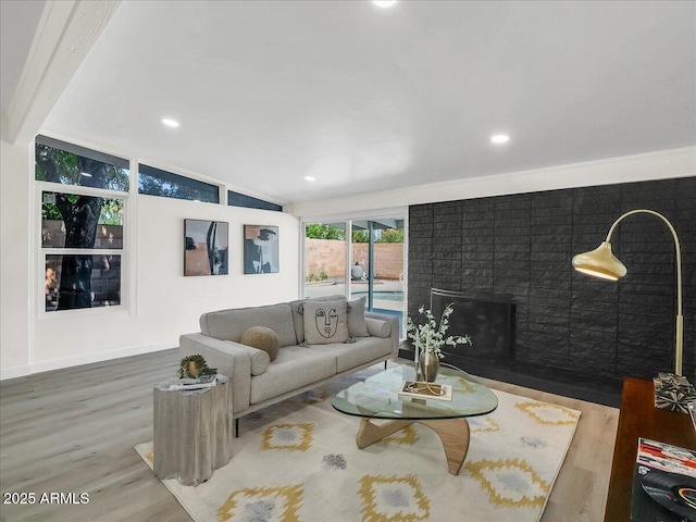 living area with a fireplace, recessed lighting, vaulted ceiling, wood finished floors, and baseboards