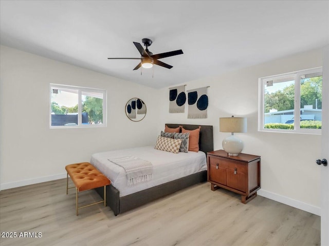 bedroom featuring baseboards, ceiling fan, and light wood finished floors