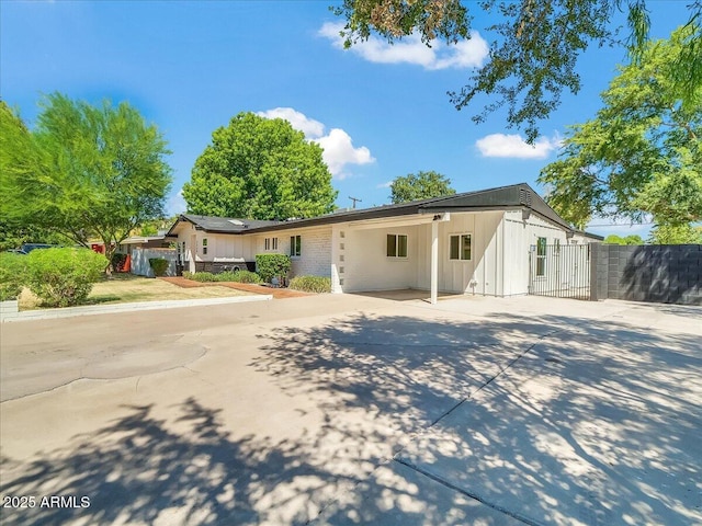 single story home featuring driveway, fence, and an attached carport