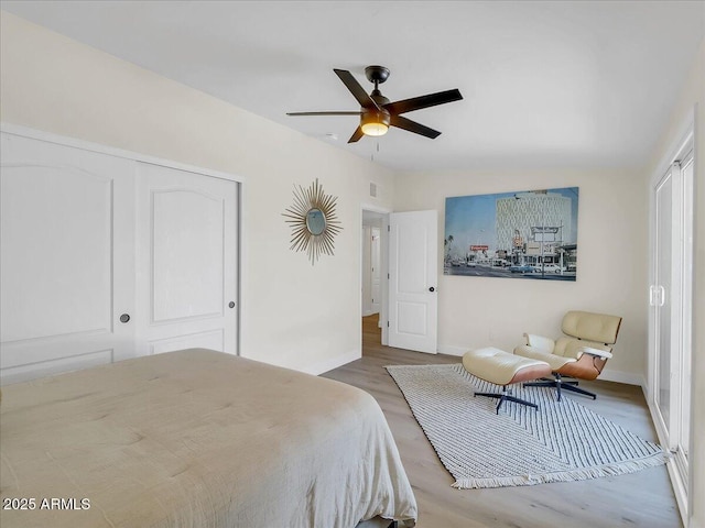 bedroom featuring visible vents, baseboards, a ceiling fan, light wood-type flooring, and a closet