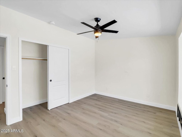 unfurnished bedroom with light wood finished floors, ceiling fan, baseboards, and a closet