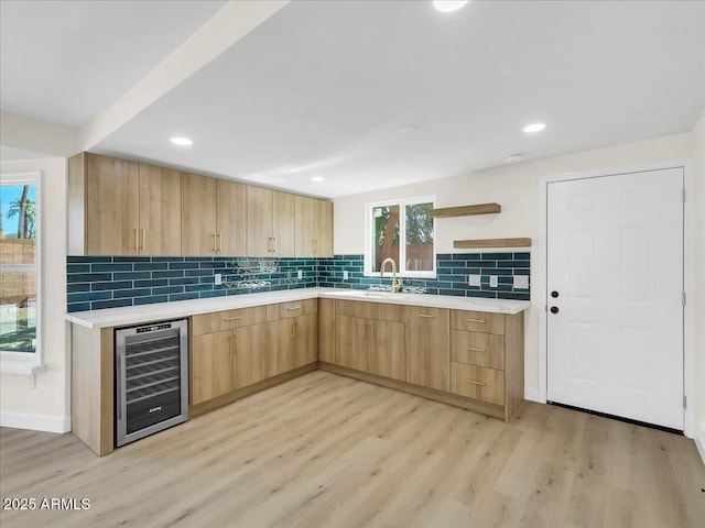 kitchen with beverage cooler, modern cabinets, light countertops, light brown cabinets, and open shelves