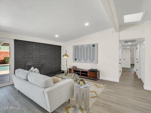 living area with baseboards, visible vents, wood finished floors, and recessed lighting