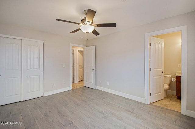 unfurnished bedroom with connected bathroom, a closet, light wood-type flooring, and ceiling fan