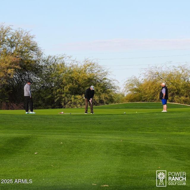 surrounding community featuring a lawn and golf course view