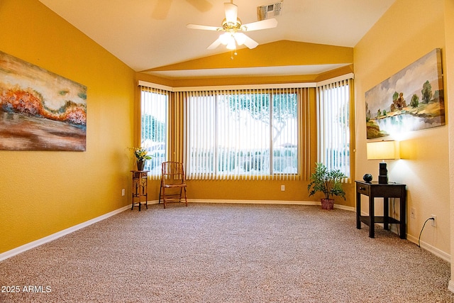 living area featuring plenty of natural light, carpet, visible vents, and vaulted ceiling