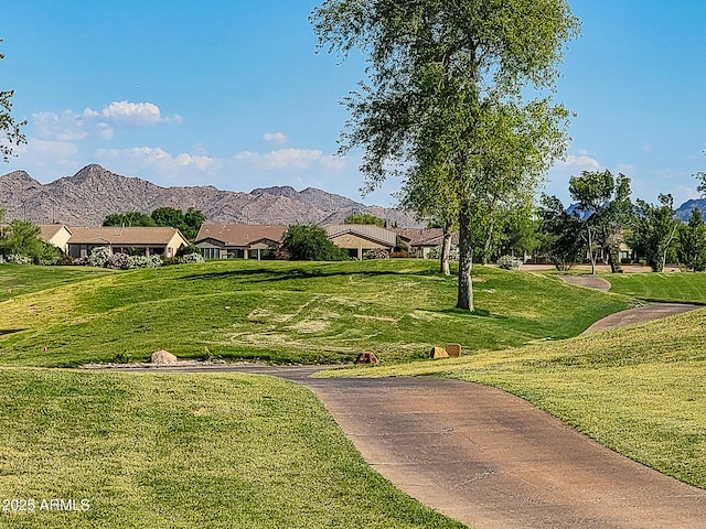 view of community with a mountain view and a lawn