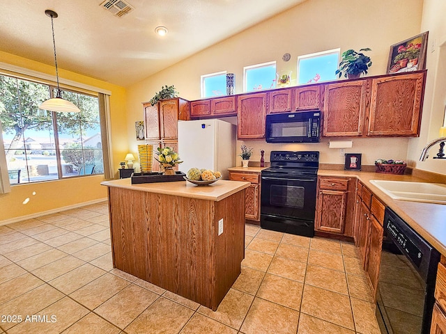 kitchen with light tile patterned flooring, a sink, hanging light fixtures, light countertops, and black appliances