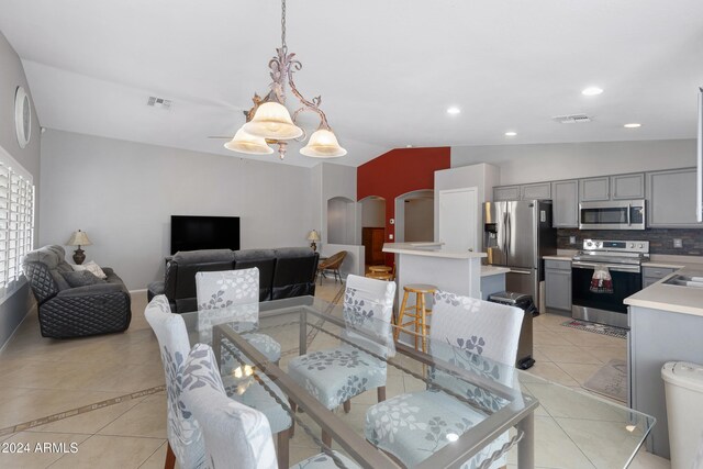 tiled dining space featuring lofted ceiling