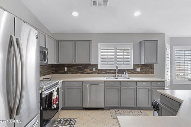 kitchen with gray cabinetry, appliances with stainless steel finishes, sink, and plenty of natural light