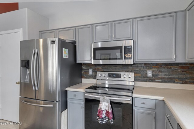 kitchen featuring gray cabinetry, tasteful backsplash, and appliances with stainless steel finishes