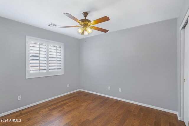 unfurnished room with dark wood-type flooring and ceiling fan